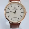 Minimalist quartz watch with gold-tone case and brown leather strap on white background