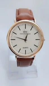 Minimalist quartz watch with gold-tone case and brown leather strap on white background